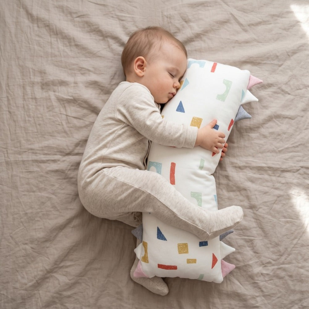 Baby sleeping while cuddling the Little Manta Willow Baby Pillow